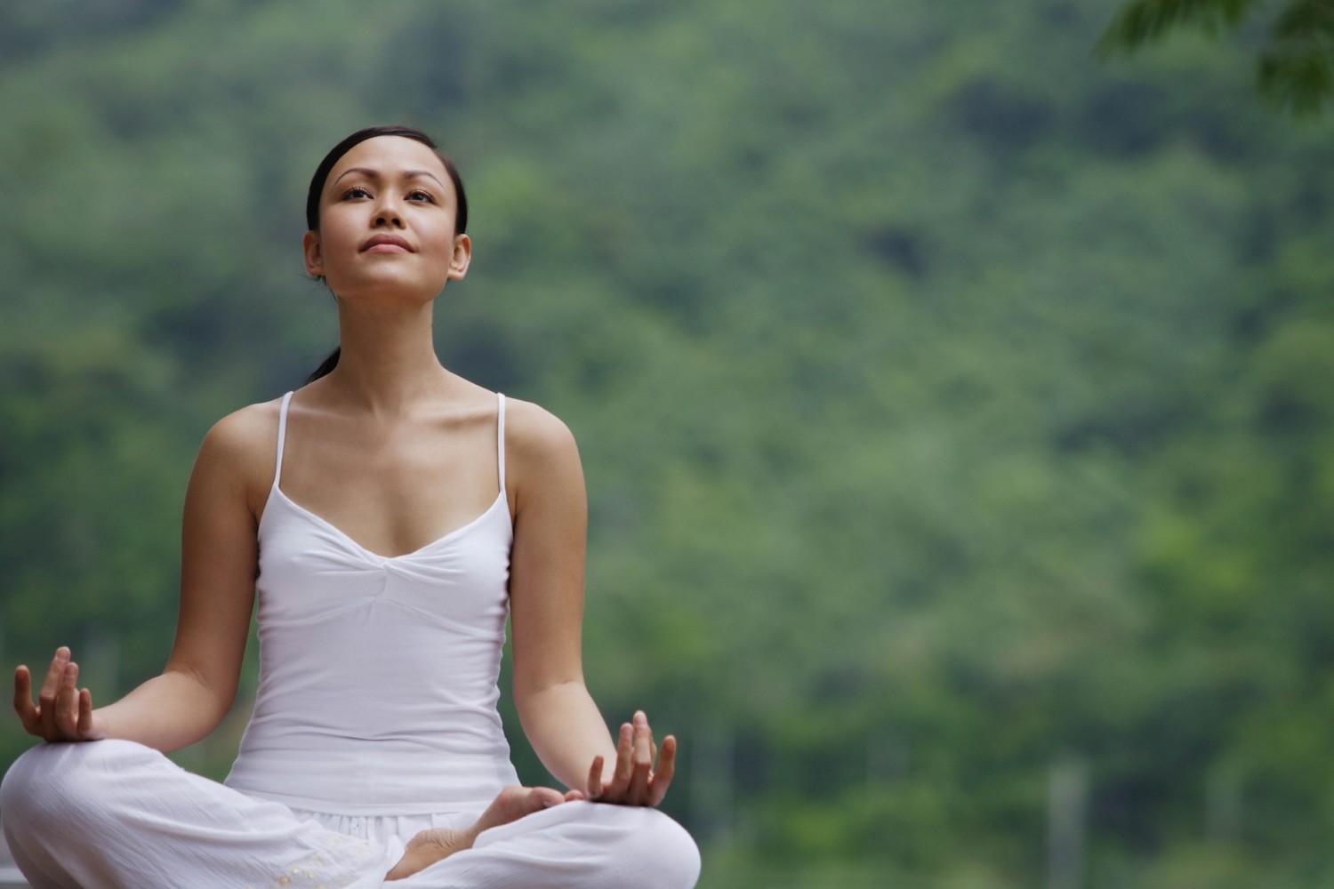 Are mindfulness and meditation the same thing - woman sitting cross-legged in nature