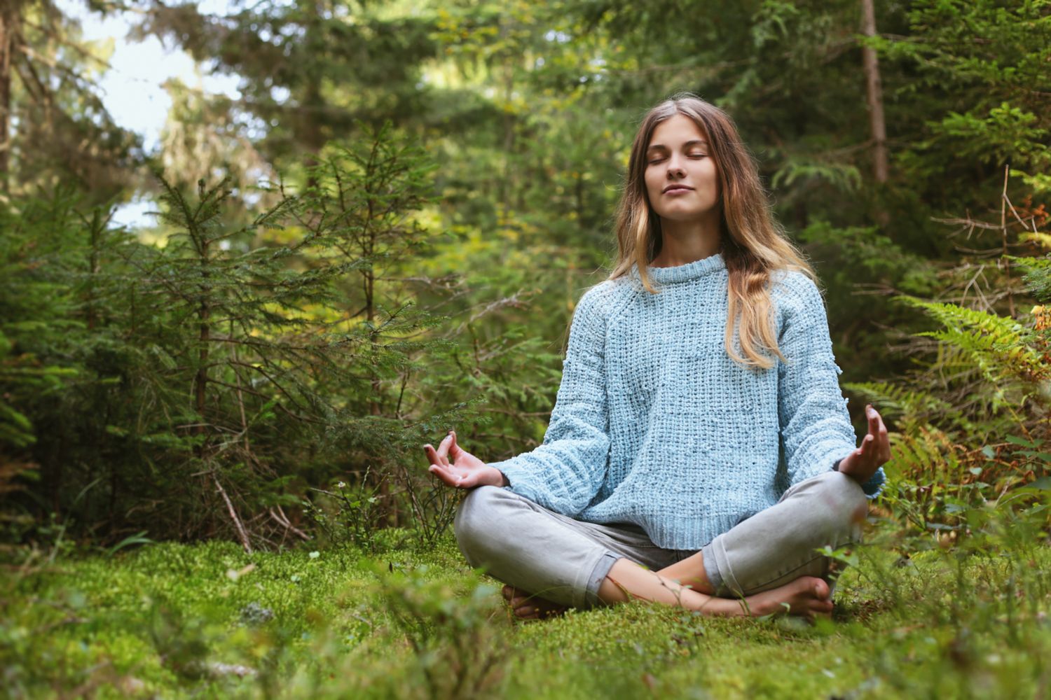 What is the most effective way to meditate - woman meditating sitting cross-legged in forest