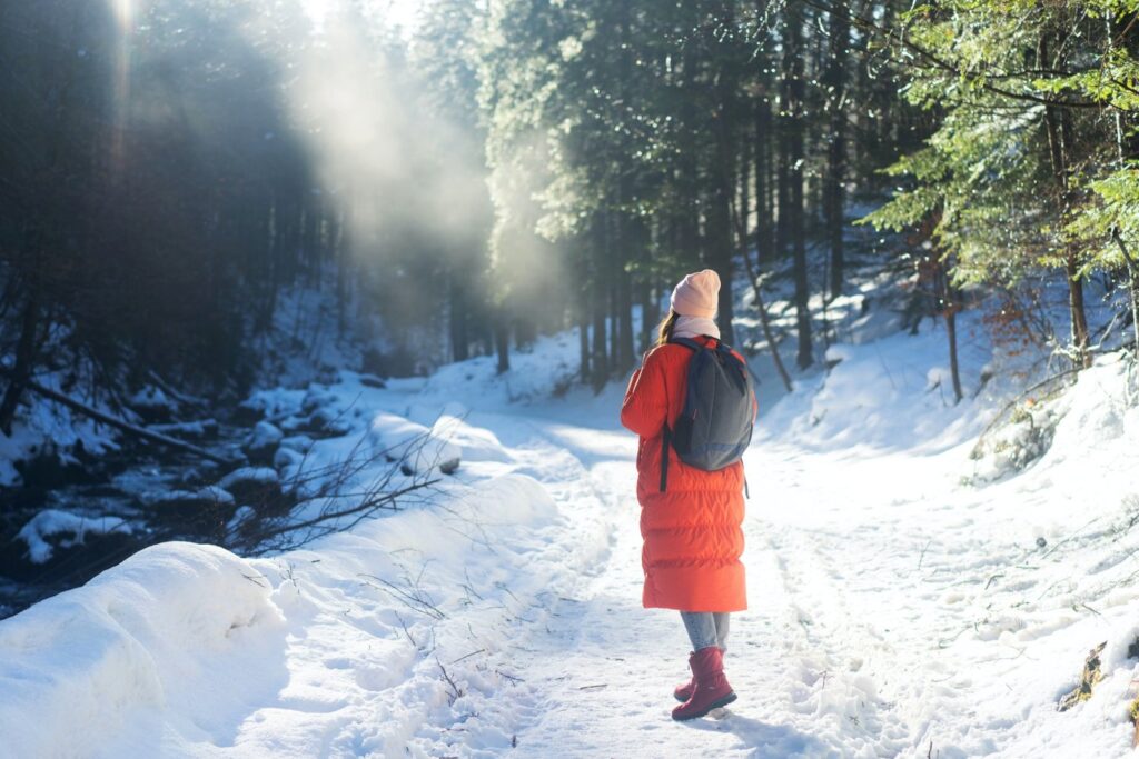 Go on a walk outside in the fresh air - Woman in red jacket in snowy forest