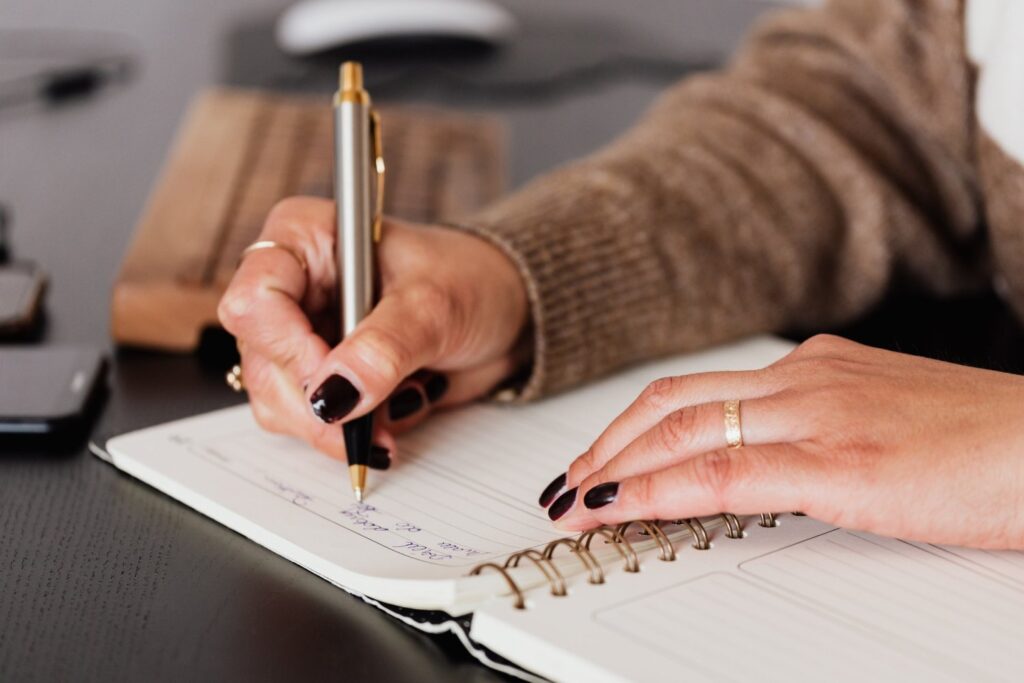 Make a list of what you're thankful for - Hands of a woman writing in journal