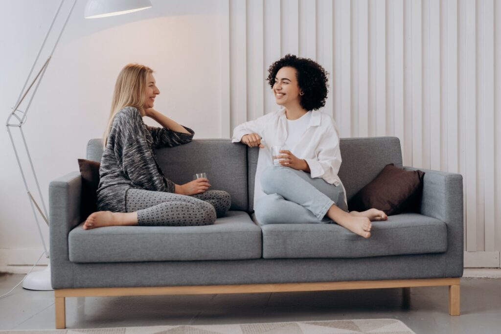 Improve your relationships and connections - Two smiling women sitting in couch