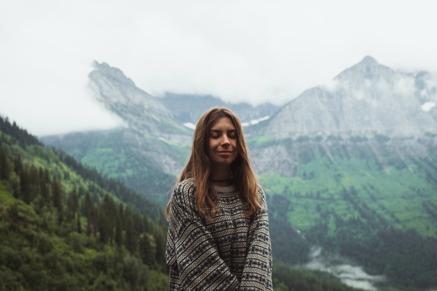 How to practice mindfulness meditation - Woman smiling with eyes closed in mountains