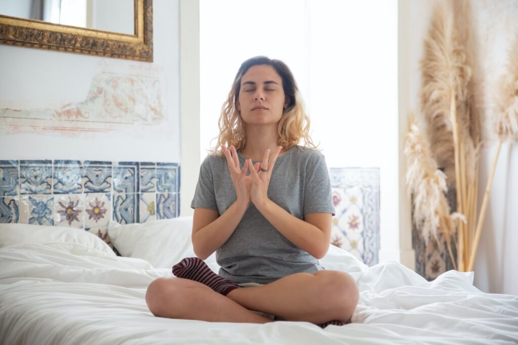 Woman meditating in bed