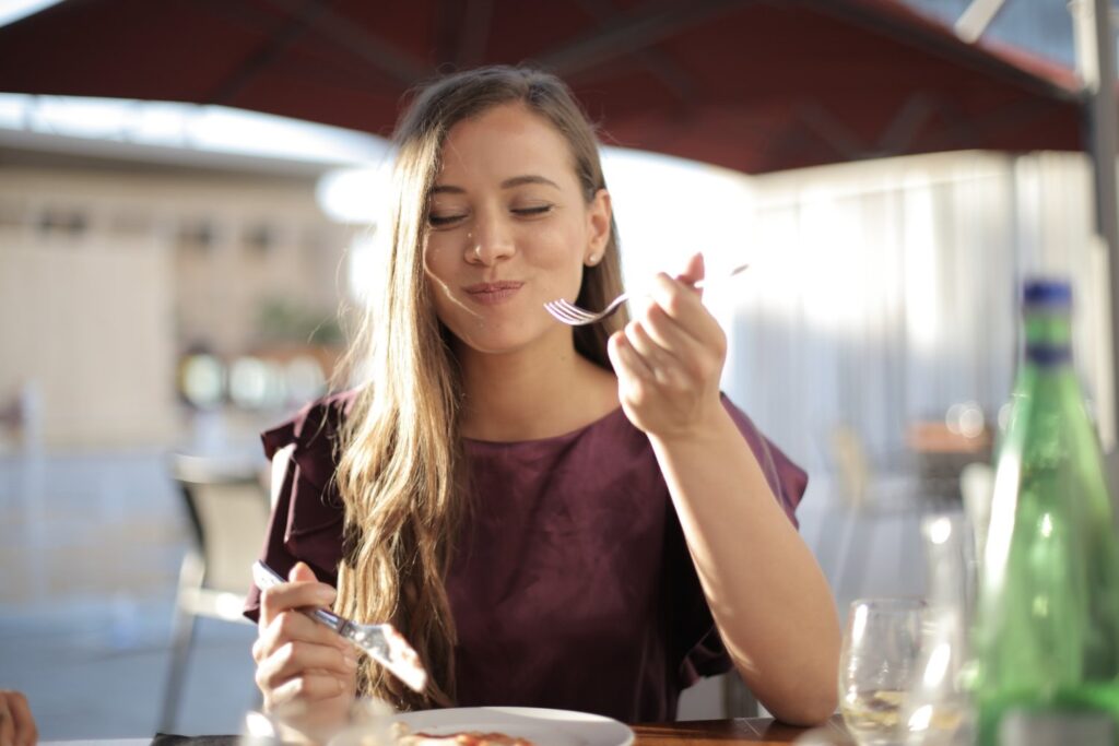 Mindful Eating - Young woman eating enjoying food