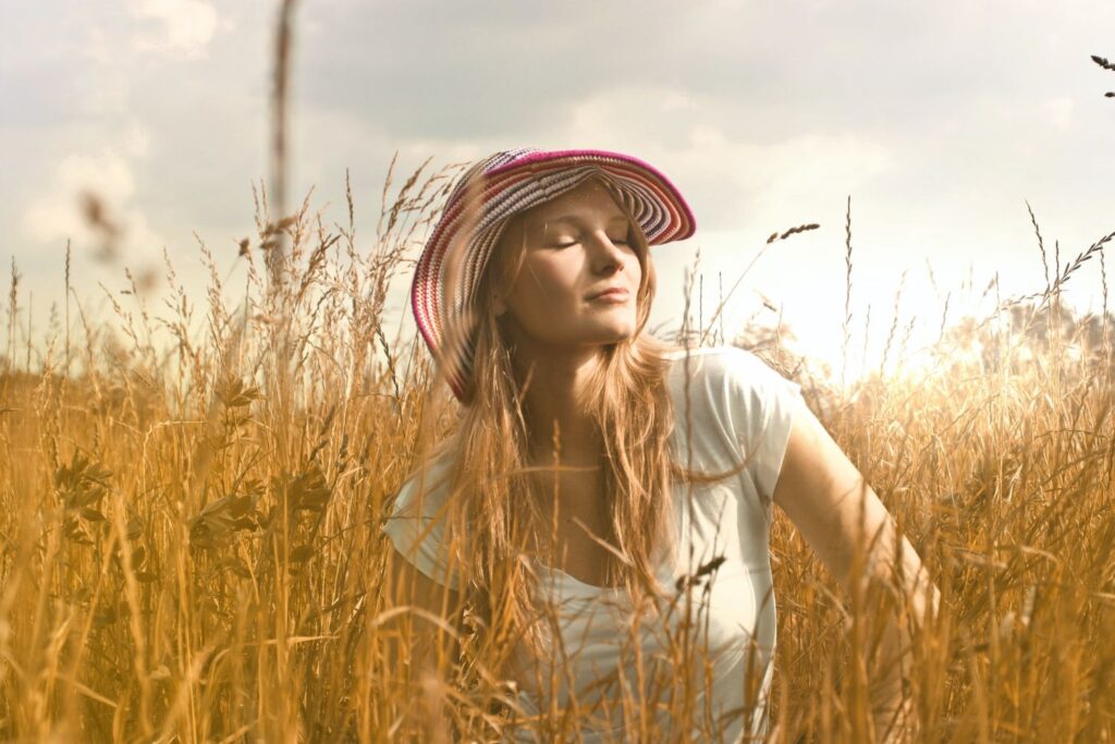 How will mindfulness help you - Woman with sun hat in yellow tall grass